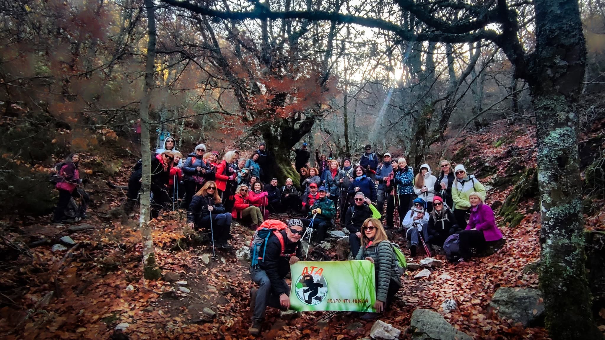 Senderistas de Grupo ATA reunidos en un bosque de otoño