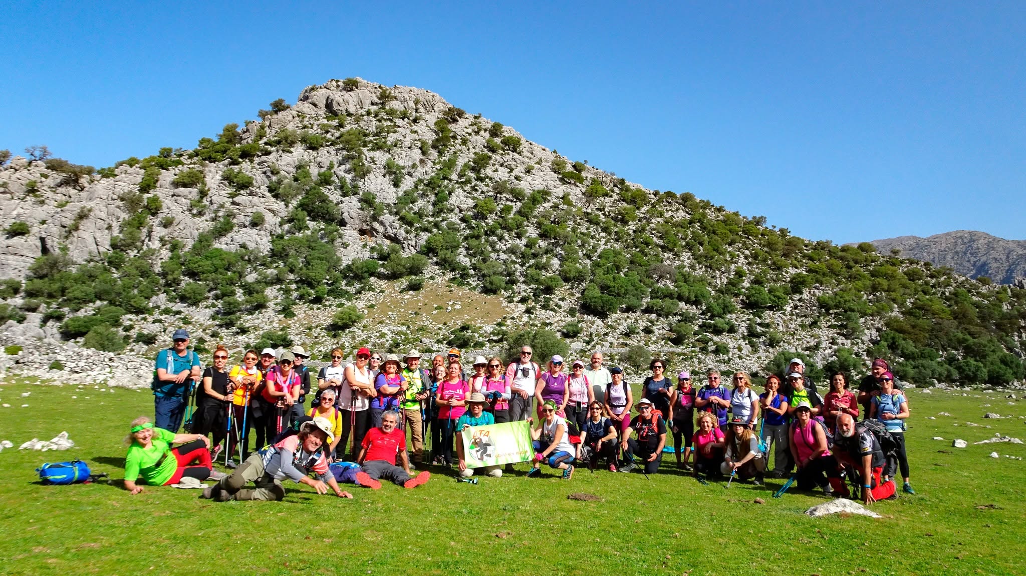 Gran grupo de senderistas de ATA en una pradera de montaña
